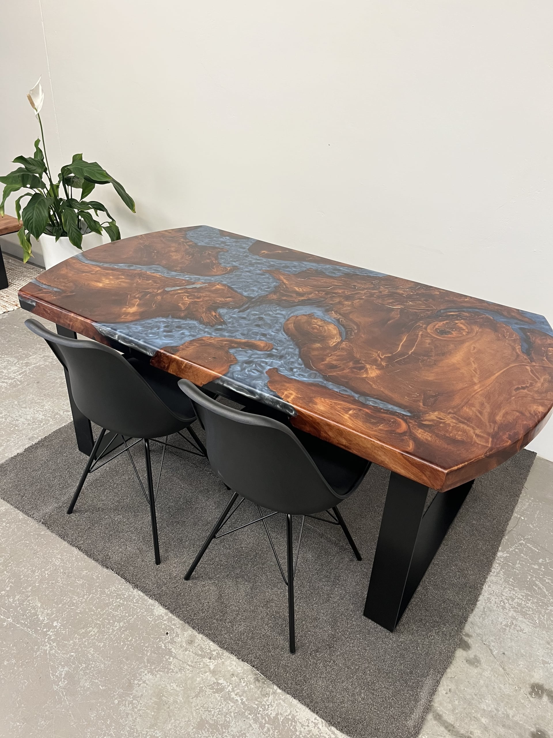 Swamp kauri dining table with blue resin and black chairs