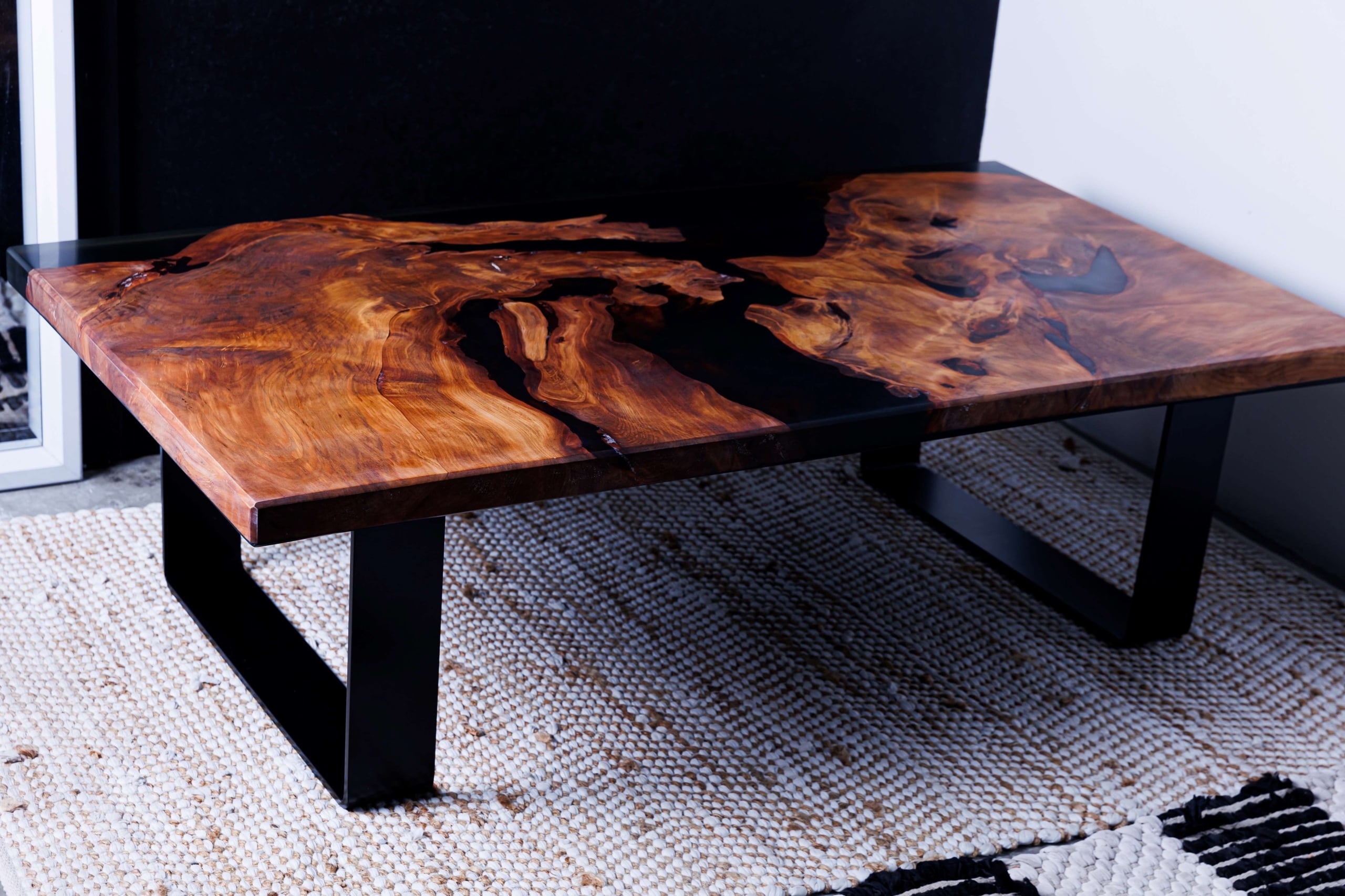 Swamp kauri coffee table with black resin and black sled legs