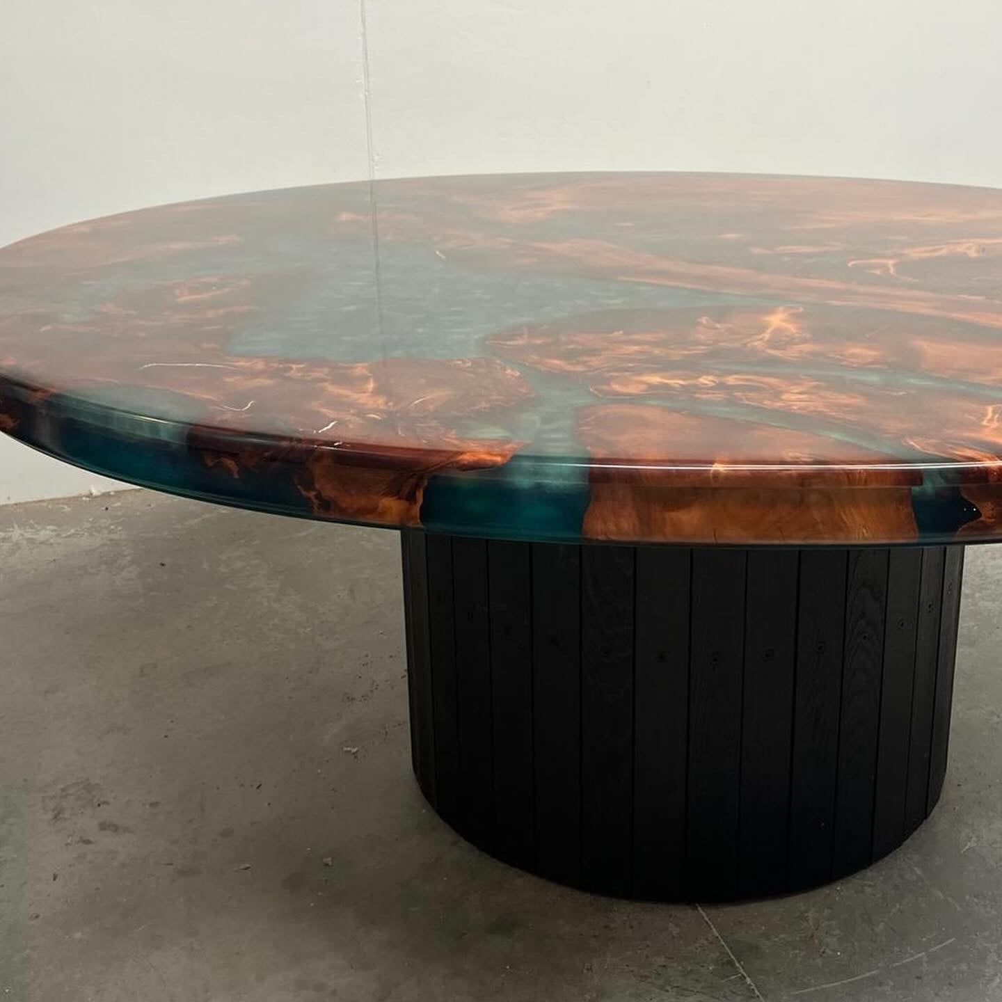 Round swamp kauri dining table with green resin on a black pedestal base
