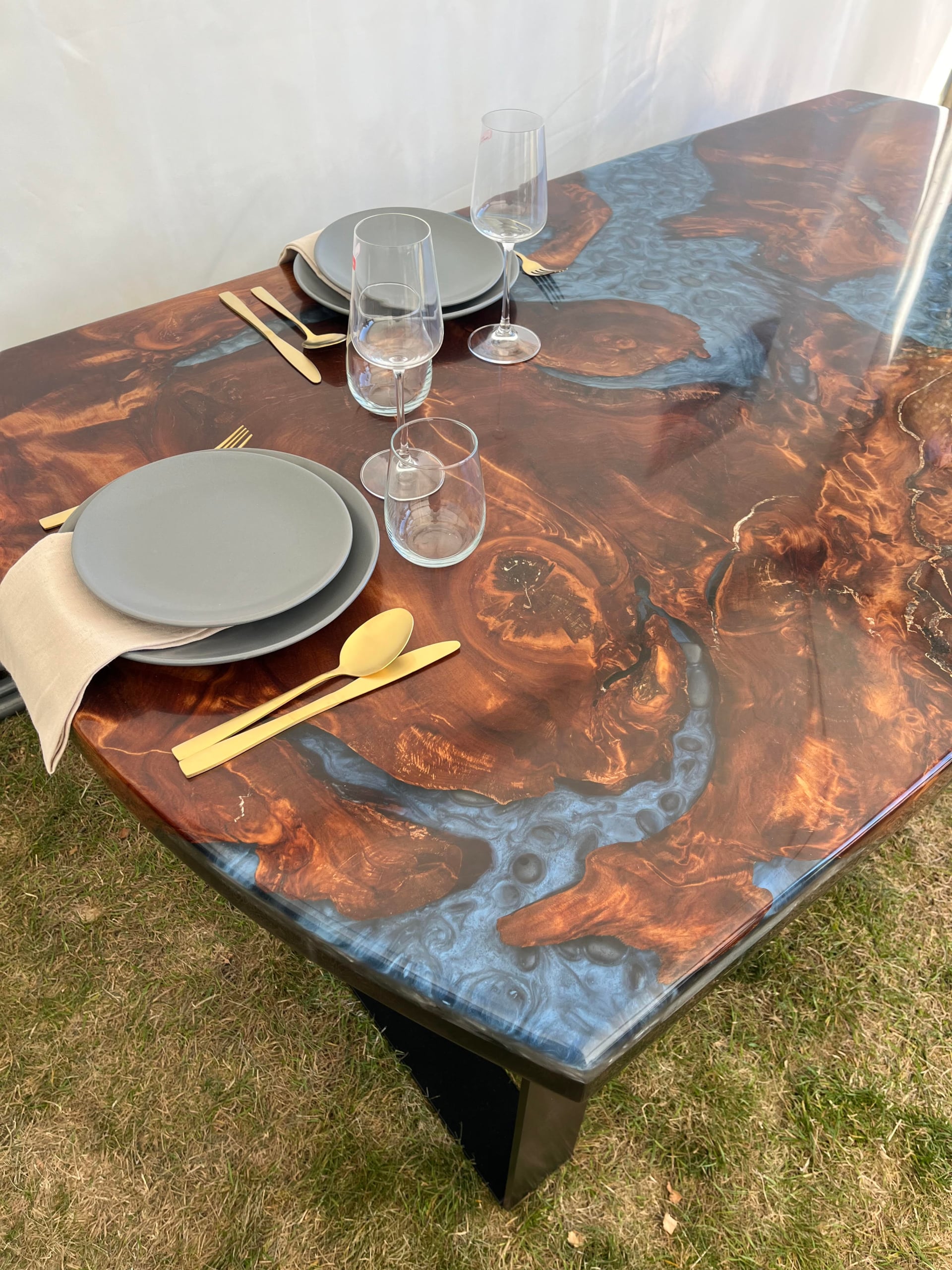 Swamp kauri dining table with metallic blue resin set for dinner